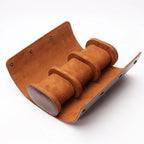 Brown roll open and empty, showing the suede-feel lining and three pillows