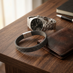 Arequipa Greek key leather bracelet on a wooden desk with a steel watch and leather wallet