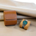 Brown 1-watch roll with a steel watch on its pillow